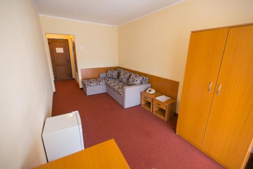 a small living room with a couch and a table at Hotel Poienița in Baile Felix