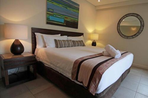 a bedroom with a large bed and a mirror at 132 Temple Luxury Direct Studio in Port Douglas