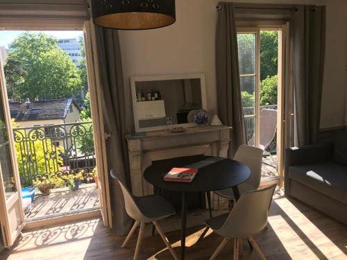 un salon avec une table et des chaises et un balcon dans l'établissement Suite Grand Hotel Palace Aix les Bains French Alps, à Aix-les-Bains