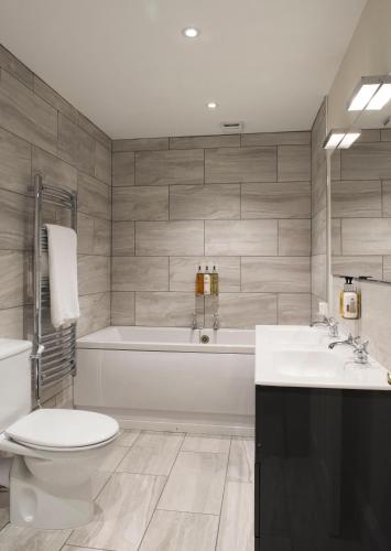 a bathroom with a tub and a toilet and a sink at Royal Seven Stars Hotel in Totnes