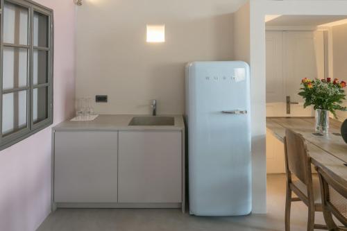 a white refrigerator in a kitchen with a table at Aria Suites & Villas in Fira