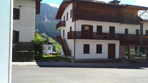 a large white building with balconies on a street at Appartamenti Kratter Valeria in Sappada