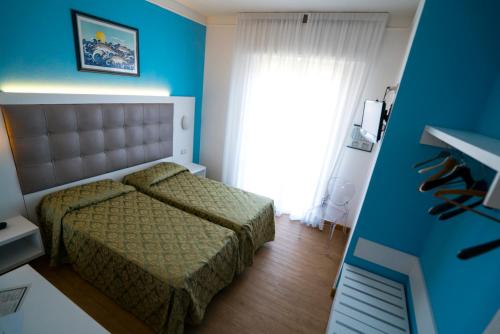 a small bedroom with a bed and a window at Hotel Oceano in Marina di Pietrasanta