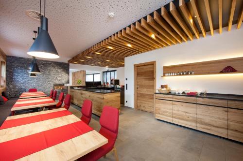 a dining room with wooden tables and red chairs at Das Heimsitz in Brixen im Thale