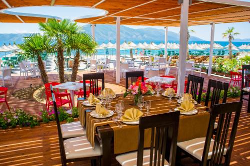 a restaurant with tables and chairs and a view of the ocean at Hotel Royal in Vlorë