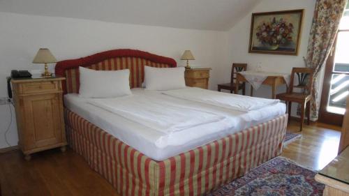a bedroom with a large bed with a red and white stripes at Gasthof Jaegerwirt in Au an der Donau