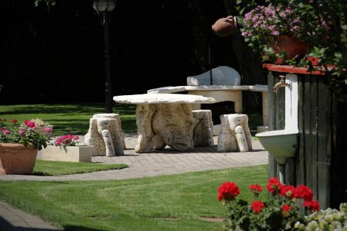 a picnic table and chairs in a park with flowers at Halász Airport Panzio in Vecsés