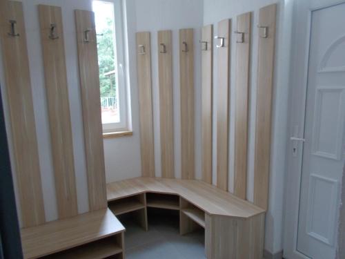 a locker room with wooden cabinets and a bench at Kristály Vendégház in Bogács