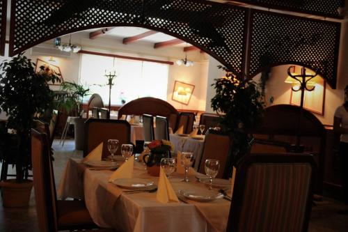 a dining room with a table with wine glasses at Halász Airport Panzio in Vecsés