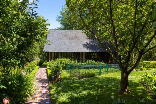 a garden with a building and a brick path at Comme une parenthèse au coeur des hortillonnages in Amiens