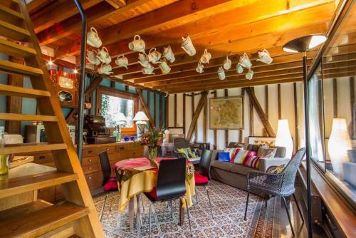 a living room with a couch and a table and chairs at Comme une parenthèse au coeur des hortillonnages in Amiens