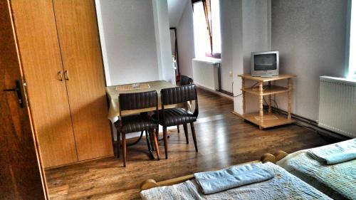 Pokój ze stołem, krzesłami i telewizorem w obiekcie Apartment Antić w mieście Sokobanja