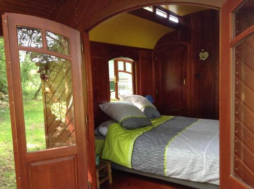 1 dormitorio con 1 cama en una habitación con ventana en les roulottes du LOT, en Gramat
