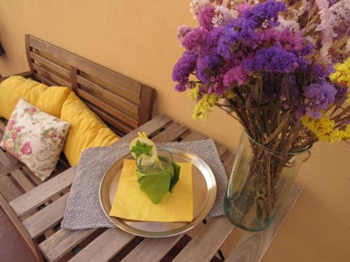 un tavolo con un vaso di fiori e un piatto con un tovagliolo di Most Art Boutique Hostel a Leiria