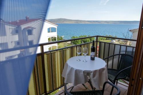 a balcony with a table with wine glasses on it at Villa Veca in Starigrad