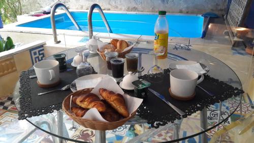 a glass table with croissants and pastries on it at Chambres et Table d'hôtes Le Jardin de Tesse in Toulon