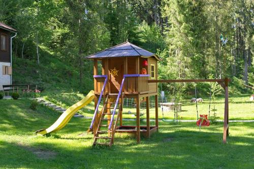a playground with a slide and a play house at Chaty Studienky in Oravský Biely Potok