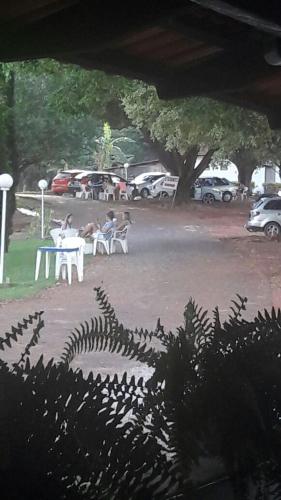 a group of people sitting at tables in a park at Hotel Fazenda e Pesqueiro Pousada da Serra in Goianésia