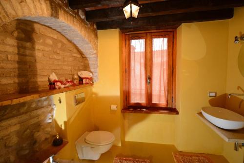a bathroom with a sink and a toilet and a window at Corte Davini Agriturismo in Monzambano