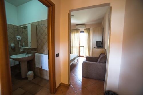 a room with a bathroom with a sink and a couch at Hotel La Maison Jolie in Fiumicino