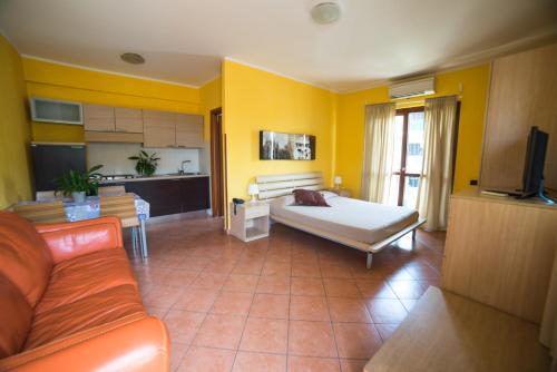 a living room with a bed and a kitchen at Hotel La Maison Jolie in Fiumicino