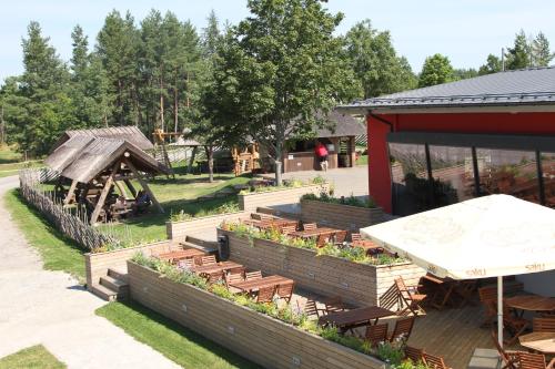 a garden with wooden benches and tables and a building at Kassariotsa Holiday House in Kassari