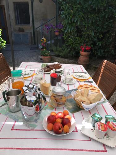 a table with plates of food and fruit on it at Antica Dimora in Monteroni dʼArbia