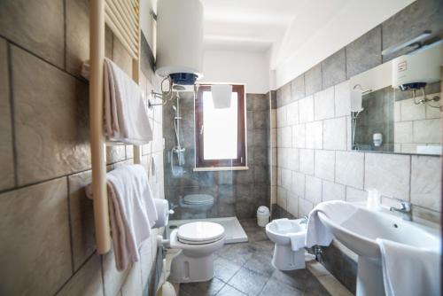 e bagno con servizi igienici, lavandino e vasca. di Hotel La Maison Jolie a Fiumicino