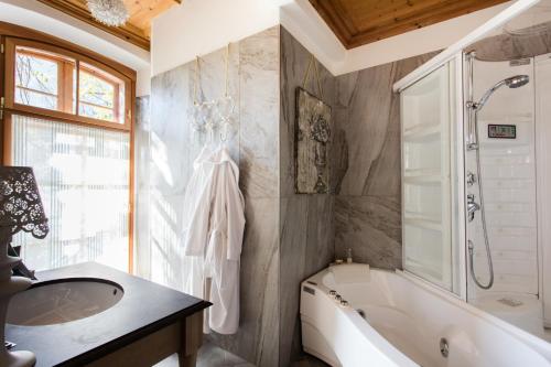 拉貢多的住宿－Schlosswirt Forst，带浴缸、水槽和浴缸的浴室