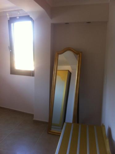 a mirror in the corner of a room with a window at Palatino Hotel in Parga