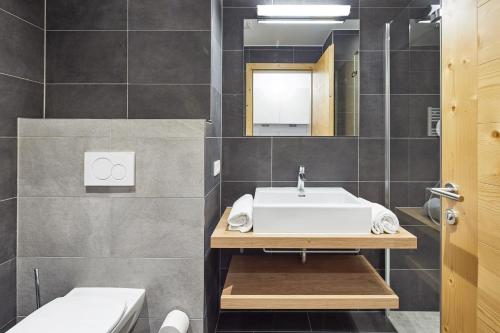 a bathroom with a sink and a toilet at Residenz Drachenstein Wildschönau in Niederau