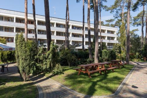 a group of picnic tables in front of a building at Jantar Medical Spa in Dziwnówek