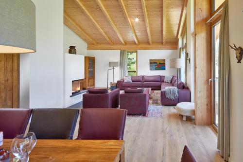 a living room with purple chairs and a table at Residenz Drachenstein Wildschönau in Niederau