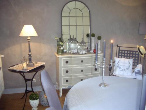 a dining room with a table and a dresser with a lamp at La maison Maria Rosa in Onzain