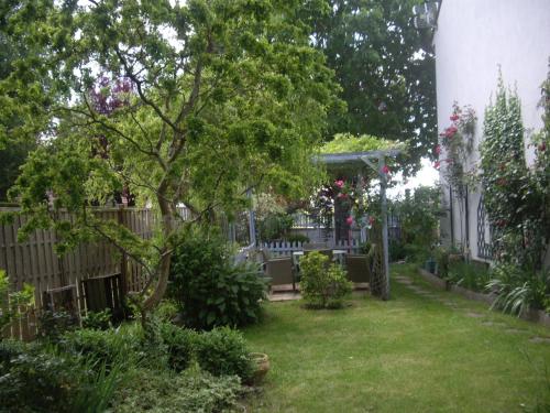 un jardín con una valla y un árbol en La maison Maria Rosa en Onzain