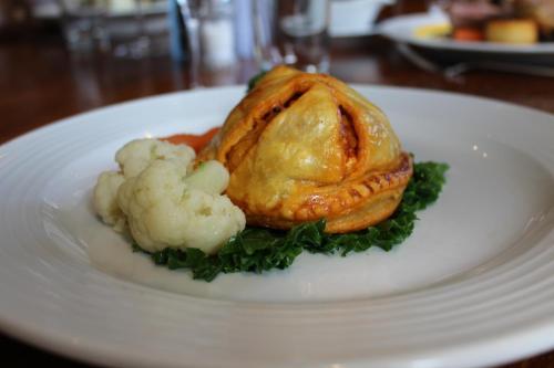 a white plate with a chicken and cauliflower on it at Blue Bell Country Inn in Knaresborough
