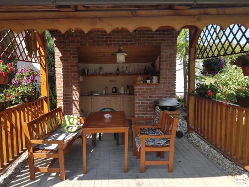 a patio with a table and chairs and a grill at Penzión Kastelán in Bojnice