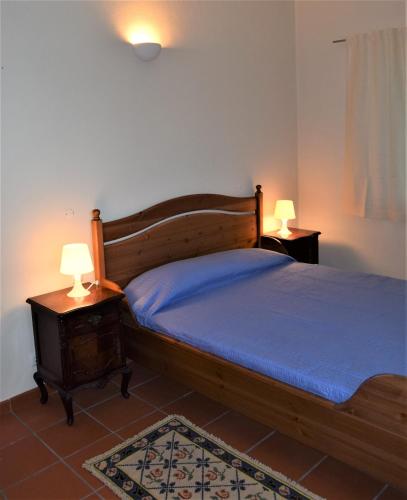 a bedroom with a bed and two night stands with lamps at Quinta da Aurora in Évora