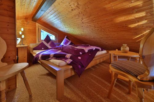 1 dormitorio con 1 cama en una cabaña de madera en Ferienhaus Mitterdorf, en Philippsreut