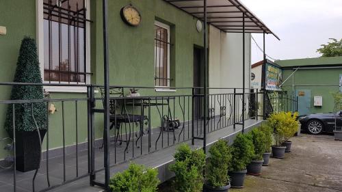 a green building with a balcony with a clock on it at Aheloy Apartments in Aheloy