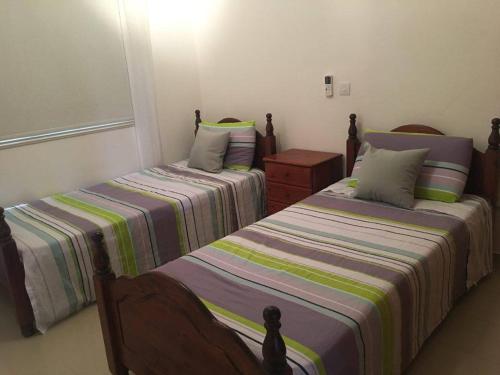 dos camas sentadas una al lado de la otra en una habitación en Paschali Sunset Appartment, en Peyia