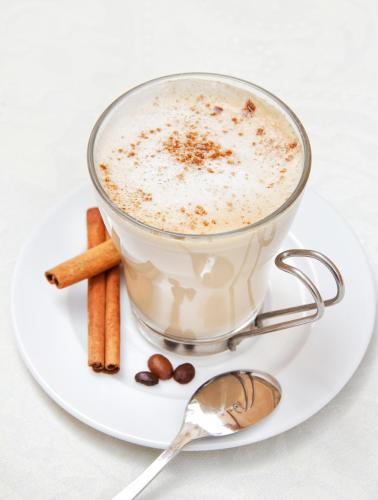 a cup of coffee on a plate with carrots and a spoon at Irati in Benidorm