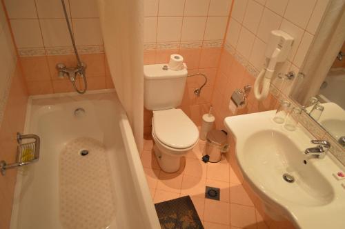 a small bathroom with a toilet and a sink at Stankoff Hotel in Nesebar