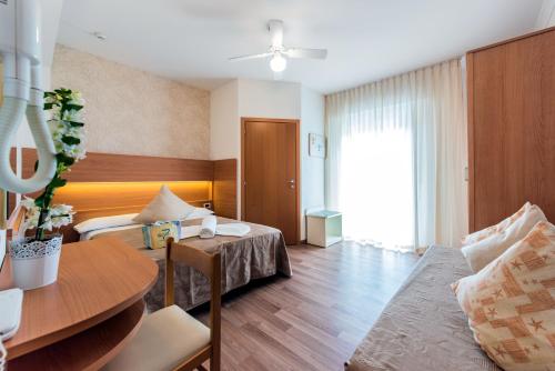 una camera d'albergo con letto e tavolo di Hotel Seven a Rimini