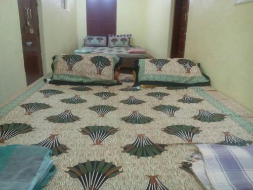a bedroom with two beds and a table in it at Raghavi Tourist Home in Kanyakumari