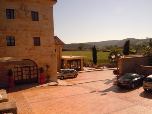 two cars parked in a parking lot next to a building at Posada La Torre de los Isla & Spa in Beranga