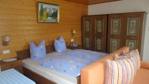 a bedroom with a large bed with blue pillows at Appartement Neumann in Finkenberg