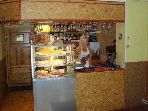 a woman standing behind a counter in a kitchen at Kuremäe Hostel in Kuremäe