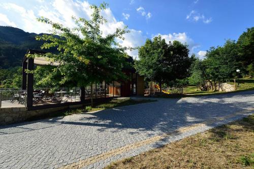 a brick road with a tree and a building at Campismo Rural Vale dos Moinhos Gerês in Geres