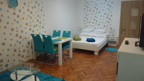 a bedroom with a table and chairs and a bed at Študio Apartman Jakobyho in Košice